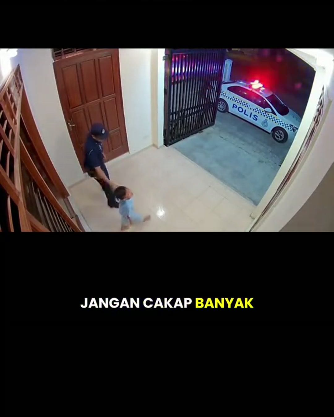 Sebuah gambar pegun daripada mikro-drama CCTV jiran yang dijana AI, menunjukkan seorang pegawai polis, seorang kanak-kanak dan kereta peronda di halaman.